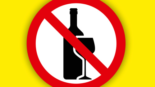 Plakatmotiv Alkoholverbot Durchgestrichene Flasche und Glas auf gelbem Hintergrund