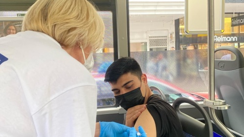 Impfbus: Ärztin impft jungen Mann Impfbus: Ärztin impft jungen Mann