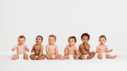 Babys Babys sitzen vor einer weißen Wand.
