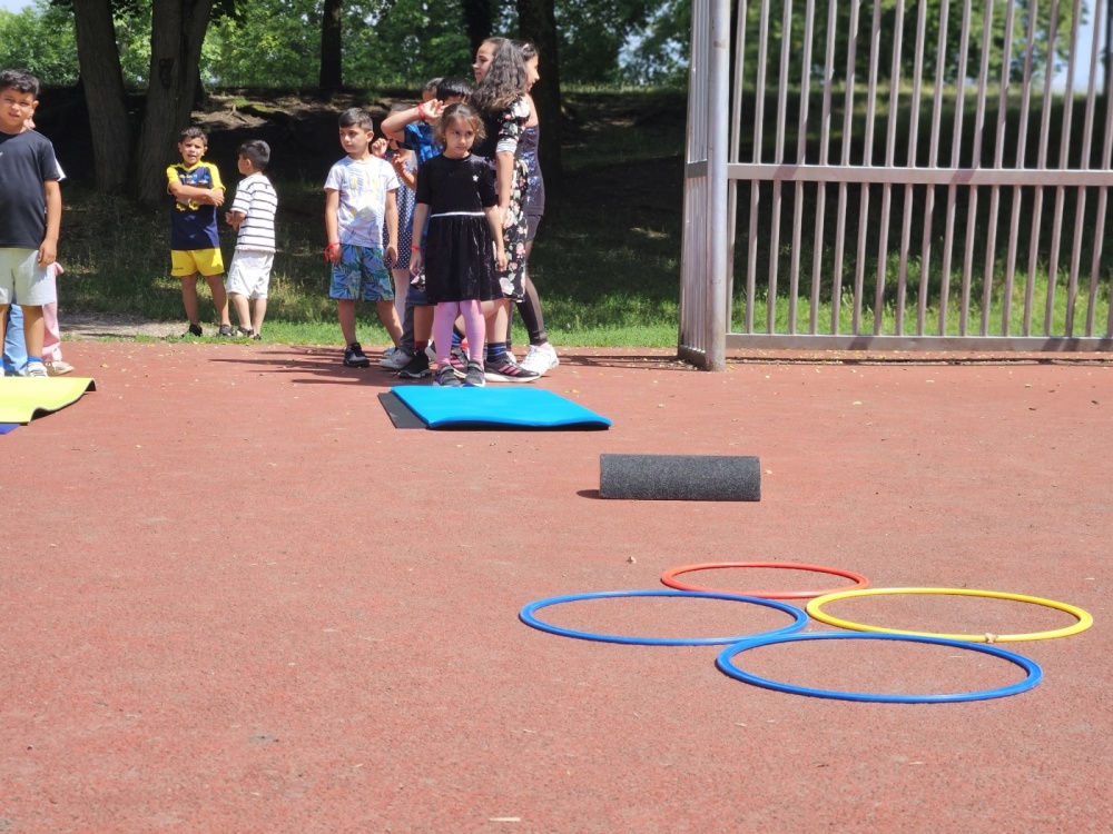 Kinderolympiade Gruppe von Kindern macht Parcour auf Sportplatz