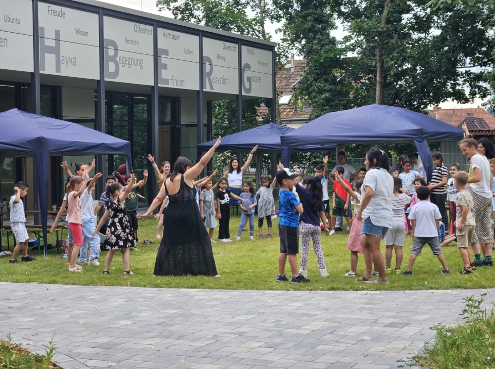 Sprachcamp 2024 Gruppe von Kinder und Erwachsenen üben Choreographie vor Bildungswerkstatt