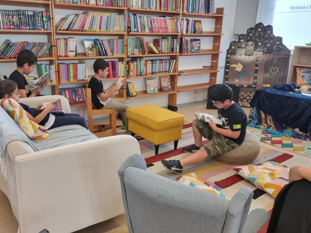 Kamishibai-Lesung im Kultur- und Lesetreff Kinder sitzen verteilt in Bibliothek und lesen