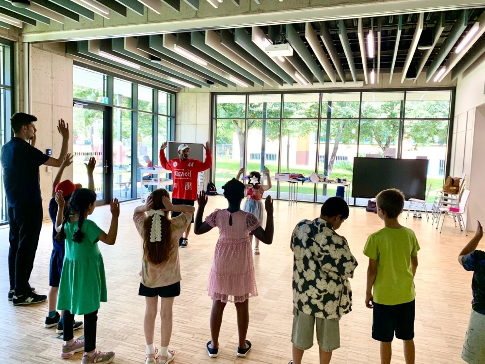 Sportwoche - Tanzen Gruppe von Kindern macht Tanzworkshop in Innenräumen der Bildungswerkstatt