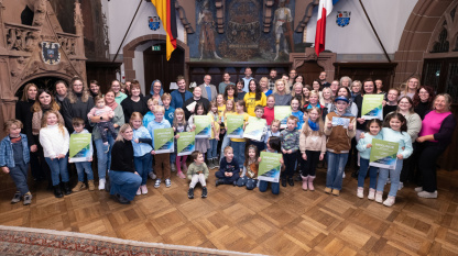 KlimaKids 2024: Preisverleihung im Rathausfestsaal KlimaKids 2024: Alle Preisträgerinnen und Preisträger, Kinder, Erzieher und Lehrer, stehen im Rathausfestsaal und zeigen ihre Urkunden