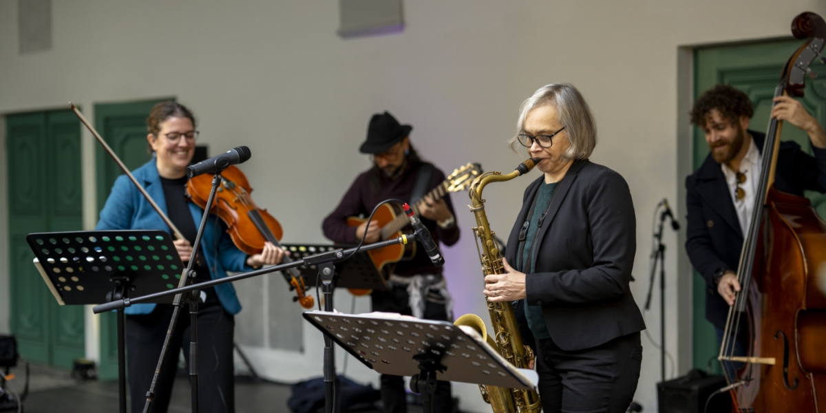 Band spielt mit Geige, Saxophon, Gitarre und Kontrabass
