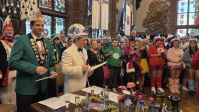 Bunt verkleidete Menschen feiern in historischem Saal