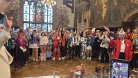 Bunt verkleidete Menschen feiern in historischem Saal