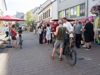 Zwei Männer unterhalten sich in einer belebten Fußgängerstraße